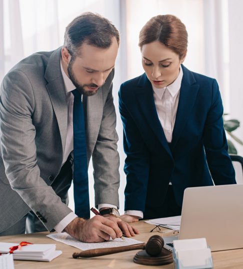 lawyers-in-suits-working-together-on-project-at-workplace-with-gavel-and-laptop-in-office lawyers-in-suits-working-together-on-project-at-workplace-with-gavel-and-laptop-in-office